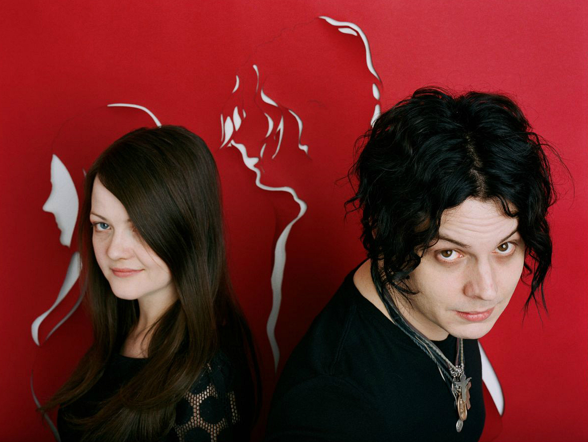Jack y Meg White en una pared roja con sus perfiles