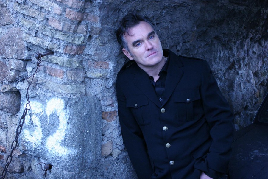 Morrissey apoyado en una pared de piedra con el número 52 pintado