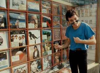 Bruce Springsteen señala sus álbumes en el escaparate de una tienda de discos.