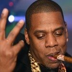 Jay Z con un puro y la mano en alto