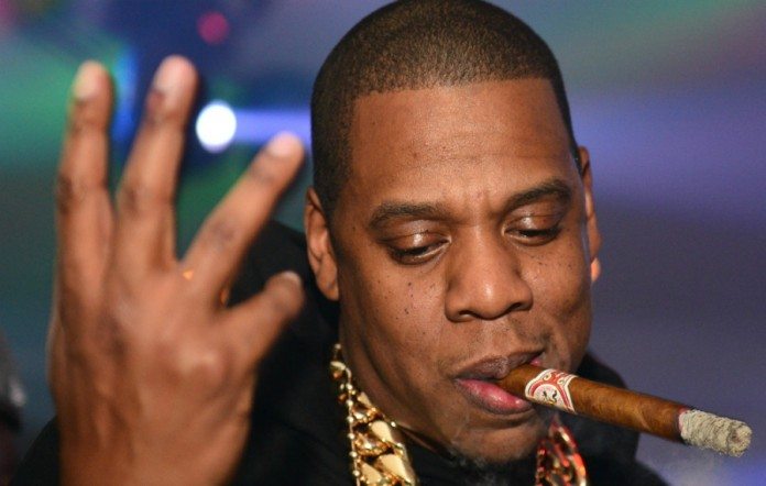 Jay Z con un puro y la mano en alto