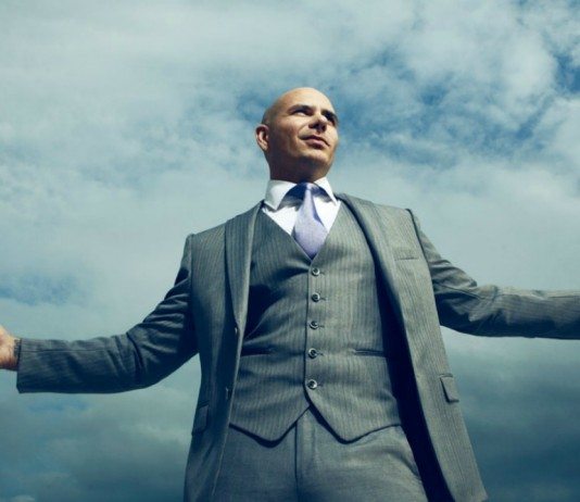 Pitbull en traje de chaqueta bajo el cielo.