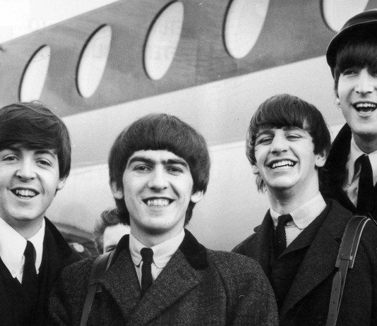 The Beatles frente a un avión, en blanco y negro