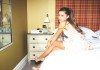 Ariana Grande sentada en la cama de una habitación.