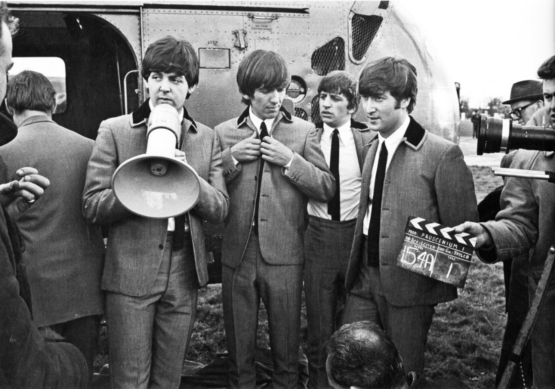 The Beatles en la grabación de una película delante de un helicóptero.