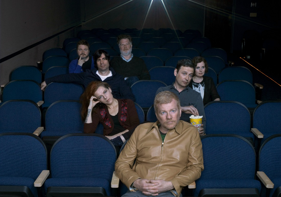 The New Pornographers sentados en las butacas de un cine.