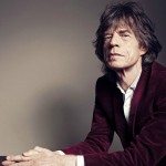 Mick Jagger sentado con un pared gris