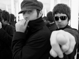 Noel Gallagher señala a la cámara junto a Liam Gallagher.